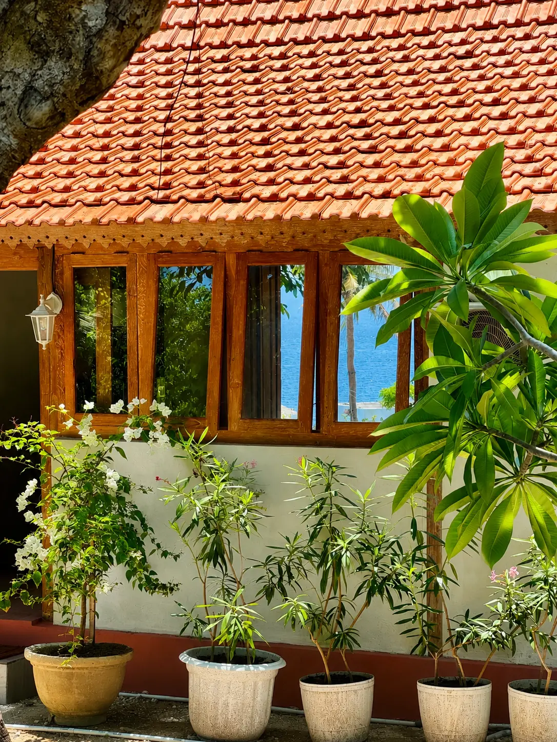Traditional tile roof pavilion with ocean view through teak windows