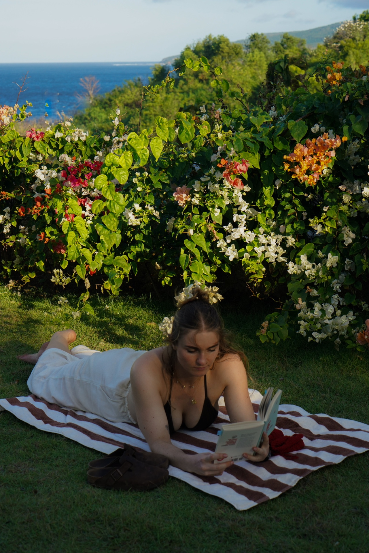Guest reading in the garden with ocean view